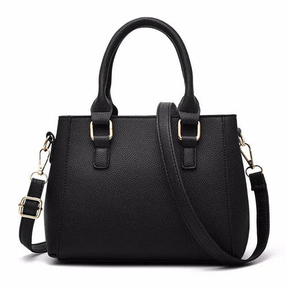 Black handbag with gold hardware on a white background