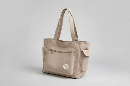 Beige handbag on a denim jacket with a white background